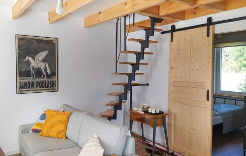 a living room with a couch and a spiral staircase at Awesome Home In Sianow With Sauna in Sianów