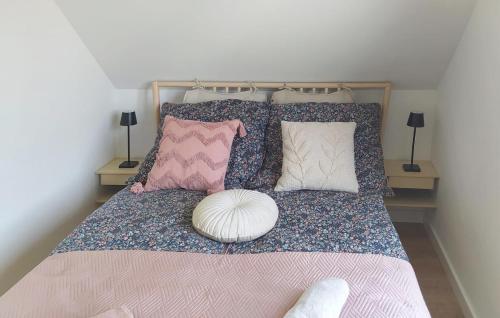 a bed with a bunch of pillows on it at Awesome Home In Sianow With Sauna in Sianów