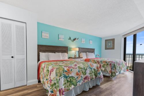ニュー・スマーナ・ビーチにあるCoastal Paradise - Amazing Ocean Views! Pool - Walk to Shopping and Dining - OT302の青い壁の部屋にベッドが2つある