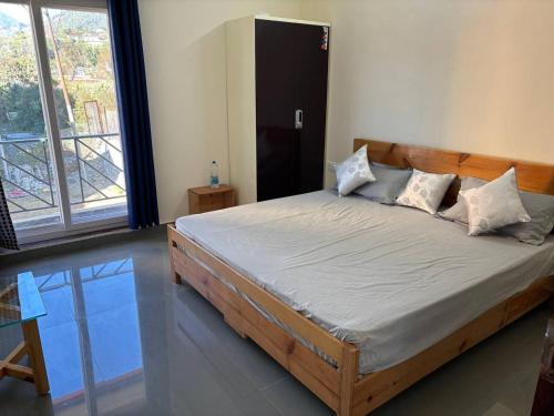 una cama en una habitación con una ventana grande en Shanti Retreat, en Bhimtal