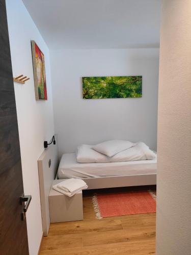a small bedroom with a bed and a painting on the wall at appartamento PANORAMA in Pozza di Fassa