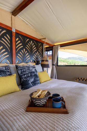 a tray of food on a bed in a room at Amperbo Glamping in Cape Town
