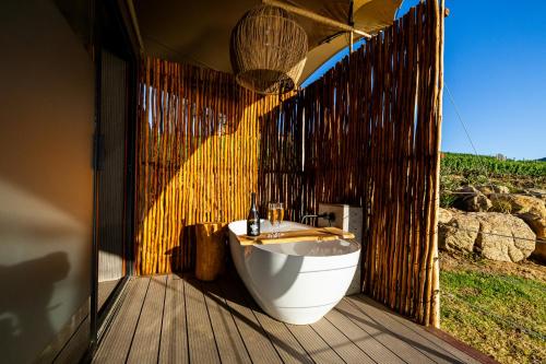 a bathroom with a tub and a sink on a wooden deck at Amperbo Glamping in Cape Town