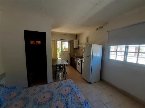 eine Küche mit einem Kühlschrank und einem Tisch im Zimmer in der Unterkunft Gotas de Rocio N1 in San Antonio Oeste