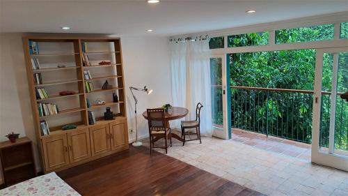 a living room with a table and a large window at Casa São Conrado in Rio de Janeiro
