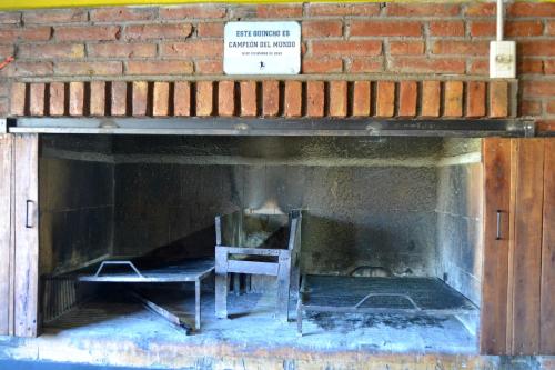a fireplace with a chair and a sign in it at Hostel Bar Valle de Potrerillos in Potrerillos