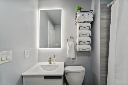 a white bathroom with a sink and a mirror at The Prospect Hill Suite - Near Yale in New Haven