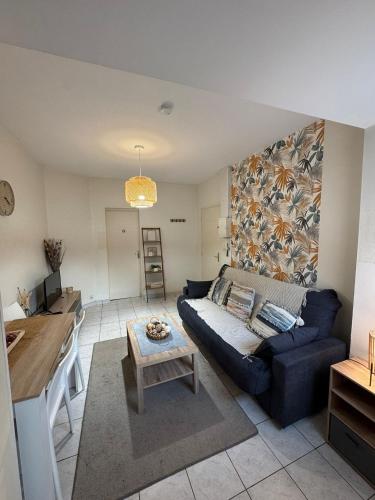 un salon avec un canapé bleu et une table dans l'établissement Le Musset, à Angers