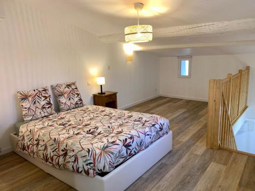 une chambre avec un lit et un parquet dans l'établissement La Reverie, au Thor