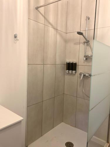 une douche avec une porte vitrée dans une salle de bain dans l'établissement La Reverie, au Thor