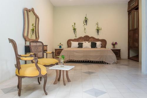 a bedroom with a bed and a chair and a table at XscapeTulum in Tulum