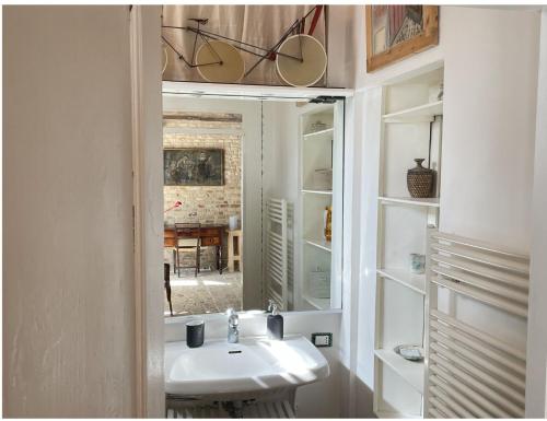 a bathroom with a sink and a mirror at "La Casa degli ulivi Art B&B" in Trecastelli