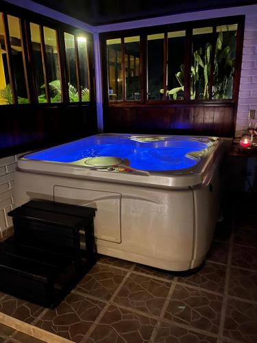 a hot tub with blue water in a room at El Ensueño Ecohostal & Glamping in Mocoa