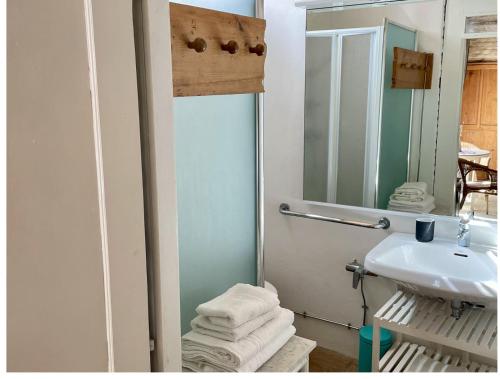 a bathroom with a sink and a mirror and towels at "La Casa degli ulivi Art B&B" in Trecastelli