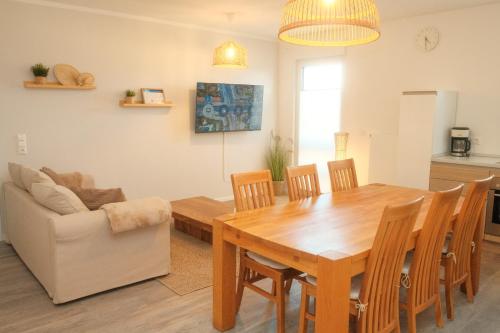 a living room with a wooden table and a couch at Seestern Strandträume - 5 min zu Fuß zum Strand in Kellenhusen