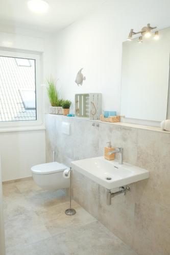 a bathroom with a sink and a toilet at Seestern Strandträume - 5 min zu Fuß zum Strand in Kellenhusen