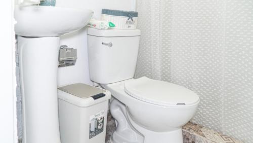 a bathroom with a white toilet and a sink at Estrella de Mar in Pedernales