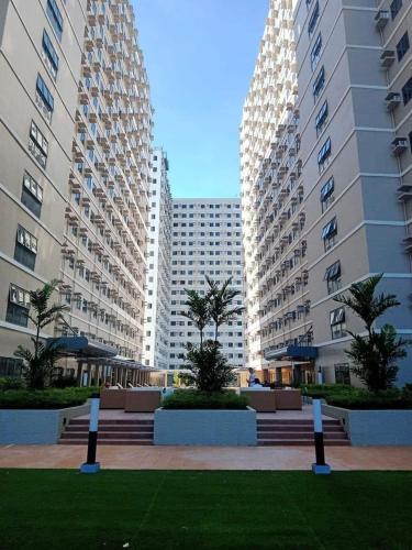 zwei hohe Gebäude mit Palmen in einem Park in der Unterkunft Green 2 SMDC - STUDIO TYPE Condo - Gems Suite Staycation in Dasmariñas