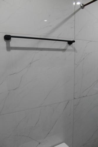 a glass shower door with a white marble wall at One Bedroom apartment A3 in Cape Town