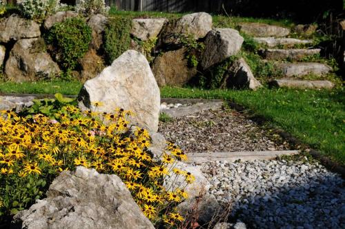 a rock garden with yellow flowers and rocks at Einkehrhof Poggau in Reinsberg