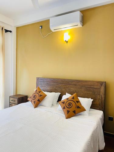 a bedroom with a large white bed with ailver at Villa Minos in Hikkaduwa