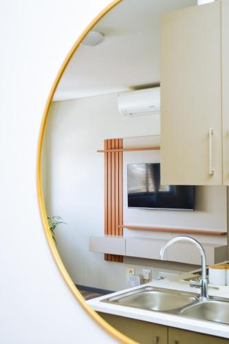 a mirror reflecting a kitchen with a sink at Mondjila Apartments in Windhoek