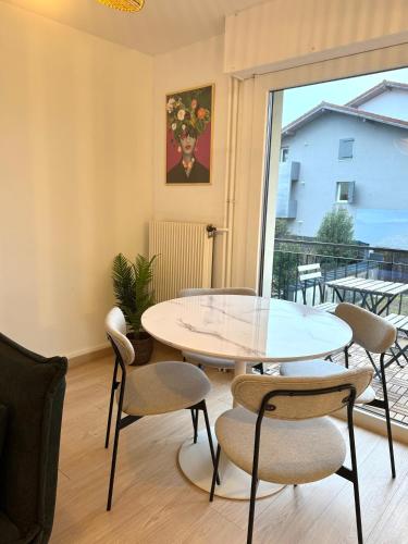 une salle à manger avec une table et des chaises en verre dans l'établissement Chaleureux studio entre lac et montagnes, à Neuvecelle