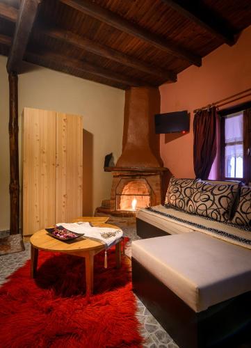 a living room with a bed and a fireplace at Konaki inn in Palaios Agios Athanasios