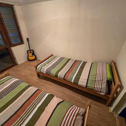 a room with two beds and a guitar in it at Vila Nera in Železnička Stanica Karlovački Vinogradi