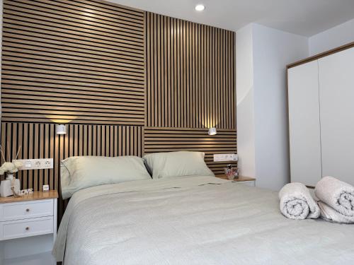 a bedroom with a large bed and a wooden headboard at Cabosun in El Cabo de Gata