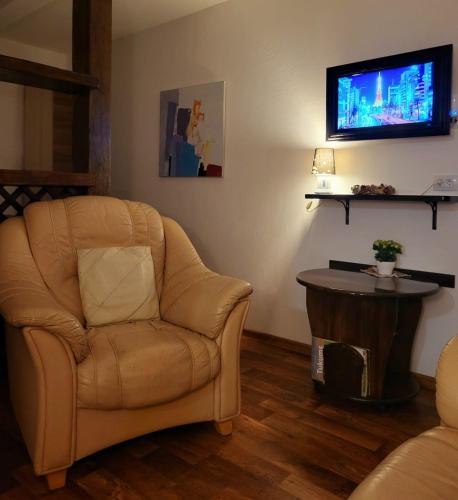 a living room with a chair and a flat screen tv at LejasVāgneris in Tukums