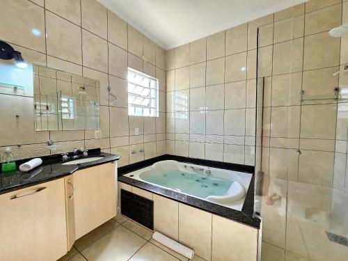 un ampio bagno con vasca e lavandino di Linda casa 5 quartos prox a av cataratas e centro a Foz do Iguaçu
