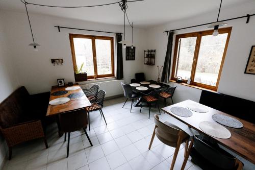 a dining room with tables and chairs and windows at Taurus Vendégház in Óbánya