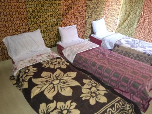two beds sitting next to each other in a room at Camp trip Merzouga in Merzouga