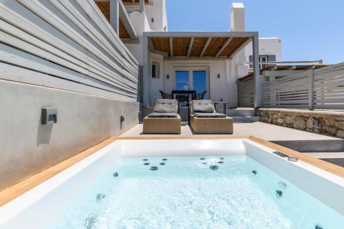 a hot tub in the backyard of a house at Mykonos Residence Villas & Suites Merchia beach in Merchia Beach