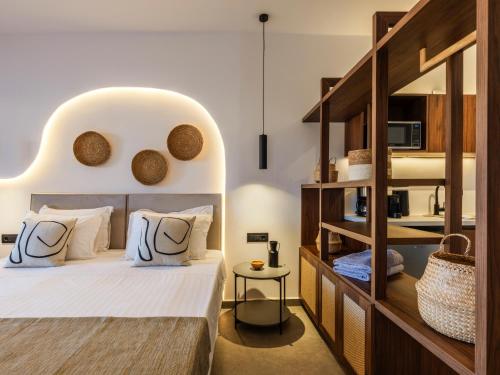 a bedroom with a large bed with a large headboard at Mykonos Residence Villas & Suites Merchia beach in Merchia Beach