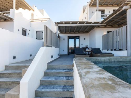 a house with a swimming pool and stairs at Mykonos Residence Villas & Suites Merchia beach in Merchia Beach