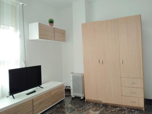 salon z telewizorem i drewnianą szafką w obiekcie Piso compartido DELYRENT, zona CorteInglés w mieście Jaén