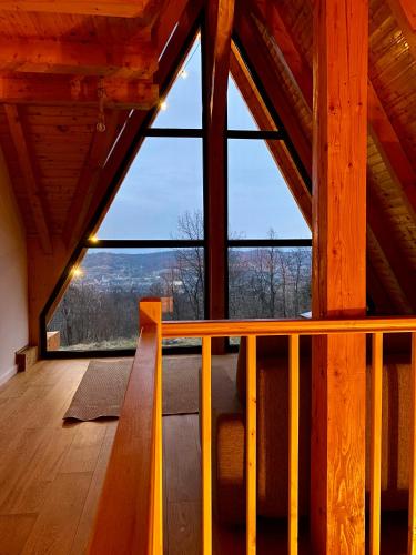 a room with a large window in a wooden cabin at Cabana Forestia - ciubăr inclus in Copalnic Mănăştur