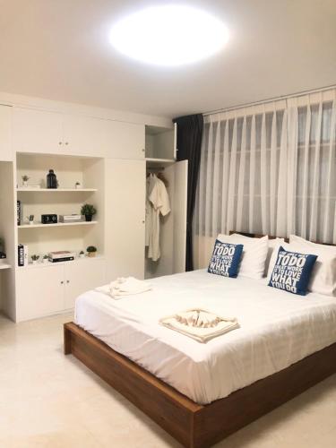Un dormitorio con una gran cama blanca con almohadas azules. en Breeze House Downtown Chatuchak, Lat Phrao, en Bangkok