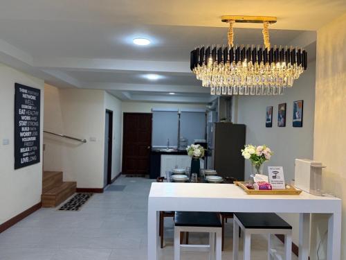 un comedor con una mesa blanca y una lámpara de araña en Breeze House Downtown Chatuchak, Lat Phrao, en Bangkok