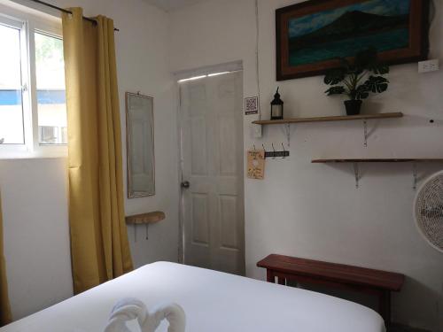 a room with a bed and a window and a door at Hostel SaltWater in San Juan del Sur
