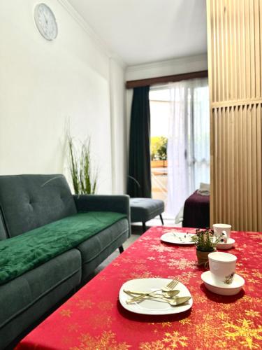 ein Wohnzimmer mit einer Couch und einem roten Tisch in der Unterkunft Studioo Apartment in Tirana
