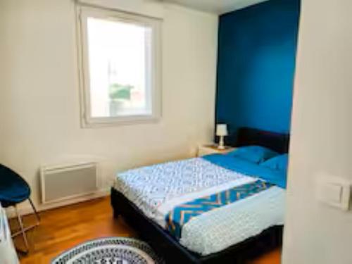 une chambre avec un lit aux murs bleus et une fenêtre dans l'établissement 3 Pièces, Paris Stade de France,parking, à Saint-Denis