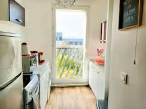 une cuisine avec un réfrigérateur et une fenêtre. dans l'établissement 3 Pièces, Paris Stade de France,parking, à Saint-Denis