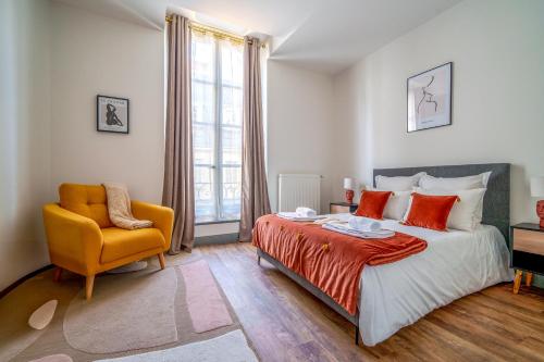 - une chambre avec un lit et une chaise jaune dans l'établissement La Plume de Colbert - By PrestiPlace, à Tours