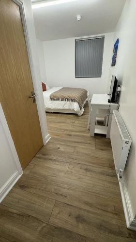 a room with a door and a bed and a desk at Sangha Hall in Leicester