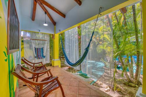 a room with two chairs and a hammock at Villas Verdes in Sámara