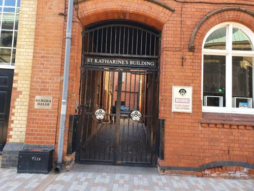 an entrance to a brick building with a black gate at Sangha Hall in Leicester