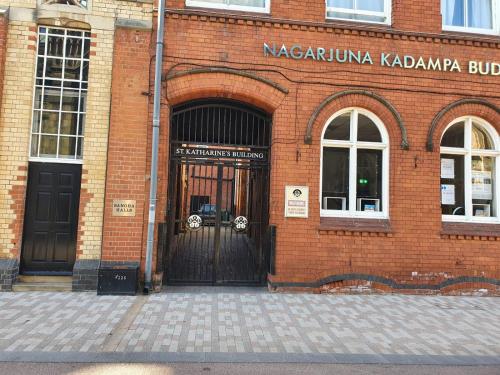 a red brick building with a large door at Sangha Hall in Leicester